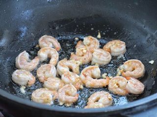 5、苦瓜炒虾仁,接着放入腌制好的虾仁，煎炒至两面变成红色。