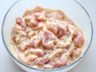 6、菠萝咕咾肉,然后放入玉米淀粉拌匀，这个量不是固定的，可以少量多次的添加淀粉，直到没有鸡蛋液，肉块上裹了一层淀粉浆为止，如图中状态