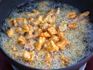 9、菠萝咕咾肉,再次升高锅中油温，将肉块复炸一遍，待肉块金黄酥脆后捞出控油
