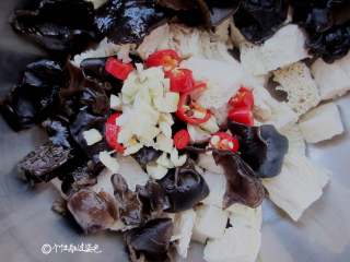 5、凉拌冻豆腐,把木耳跟冻豆腐放一起,放入蒜米、小米椒