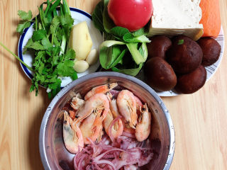 1、海鲜豆腐煲,准备好食材。虾、八爪鱼、豆腐、香菇、油菜、西红柿、胡萝卜、葱姜蒜、香菜。