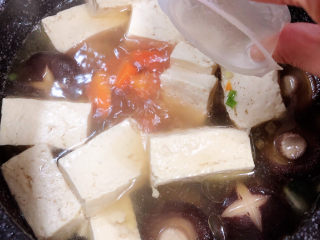 12、海鲜豆腐煲,煮开锅后，放入一个骨汤浓汤宝。盖盖儿小火儿炖煮5分钟。