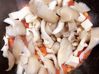 13、平菇豆腐汤,再加入平菇，翻炒均匀。