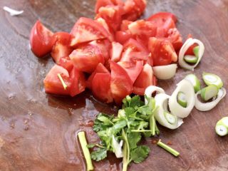 2、番茄牛腩面,把番茄洗净后切块,葱切碎,香菜切段。