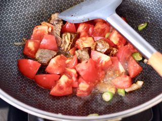 5、番茄牛腩面,大火继续翻炒至番茄变软。