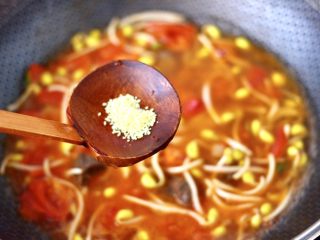 10、番茄牛腩面,看见黄豆芽变软后,锅中倒入适量的清水,加入鸡精调味。