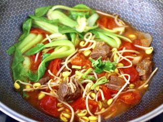 12、番茄牛腩面,看见青菜断生变色的时候关火,淋上芝麻油撒上香菜段即可。