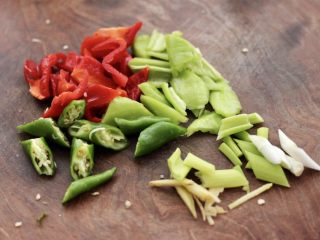 3、杏鲍菇虾仁三椒小炒,把青椒和红椒,杭椒用刀切块,葱姜切丝。