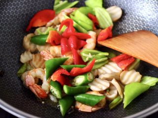 12、杏鲍菇虾仁三椒小炒,加入青椒和红椒,杭椒,大火继续翻炒均匀。