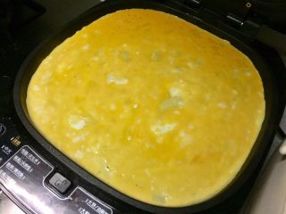 6、黄金黑米卷,把鸡蛋液翻去电饼铛,晃匀。