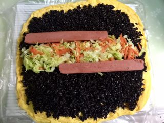 14、黄金黑米卷,然后在黑米饭中间放上蔬菜和火腿。