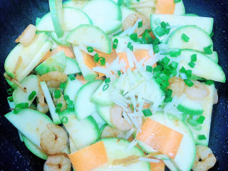 11、西葫芦炒虾仁,加入葱蒜翻炒均匀。