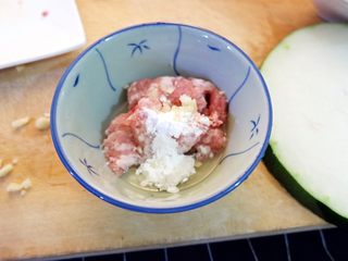 2、宝宝辅食之肉末蒸冬瓜+冰糖水蜜桃,先处理肉末。肉末加四分之一个鸡蛋清,一勺淀粉,一点蒜末拌匀,再淋少许油腌制
