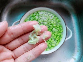 6、毛豆炒肉丝,用手轻轻揉揉毛豆，把毛豆外面一层外衣搓下来。