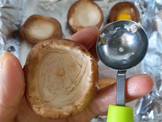 5、香菇烤太阳,用挖球器把香菇肉再挖走一点,不然鹌鹑蛋会流出来。如果是大的香菇就忽略