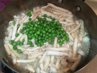 11、健康低卡香煎鲈鱼,继续把刚刚煮好的小豌豆放入锅中。菇会炒出水分。