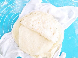 10、土豆酱肉丝卷饼,烙好的饼有均匀的糊斑，取出放入干净的布中包起来，温热时开一分为二，在用布包起来放入密封的盆中或者锅中，以方变干。