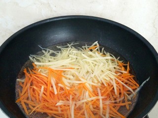 11、土豆酱肉丝卷饼,土豆和胡萝卜擦丝，放入热开水中辍水变透明，捞出过凉水。