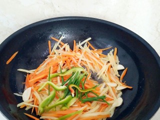 14、土豆酱肉丝卷饼,放入土豆丝和胡萝卜丝，还有一半的青椒丝大火翻炒10秒钟，淋入香醋关火，调入2克盐，香葱段，鸡精调味出锅备用。