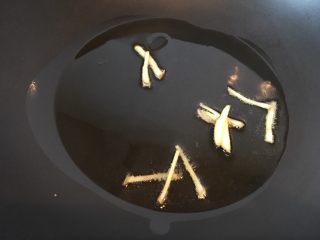 6、大蒜牛肉片,热油滑锅,放入姜丝炒香。