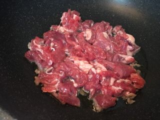 7、大蒜牛肉片,放入牛肉片,快速大火翻炒。