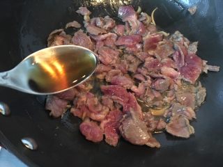 8、大蒜牛肉片,放入料酒和盐翻炒均匀。