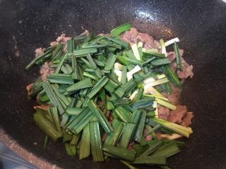 9、大蒜牛肉片,放入大蒜叶翻炒均匀。