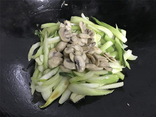 10、蘑菇炒菜梗,加入刚才炒过的蘑菇一起翻炒均匀。