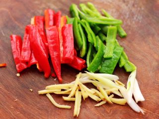 3、啤酒焖红蟹鱼,把青椒和红椒去掉籽后，用刀切成丝，葱姜切丝。