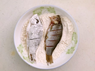 13、香煎鲫鱼,把鲫鱼放入面粉中打个滚，让鲫鱼均匀的裹上一层薄薄的面粉