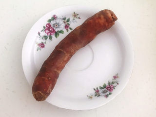 5、蒜苗炒腊肠,把煮熟的腊肠夹出来