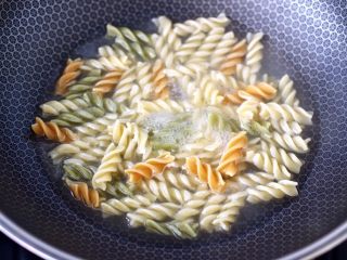 4、香煎三文鱼&炒意面,锅中倒入适量的清水,放入彩色意面大火煮开后,转小火煮熟捞出过冷水后沥干备用。