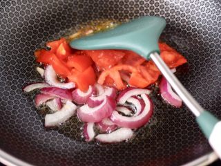 8、香煎三文鱼&炒意面,锅烧热后倒入剩下的10克橄榄油,先炒香洋葱后加入番茄。