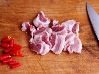 2、蒜香花肉小苔菜,五花肉洗净后用刀切成薄片，小米椒切段备用。