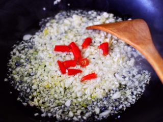 5、蒜香花肉小苔菜,大火爆香蒜末后，放入小米辣继续翻炒片刻。