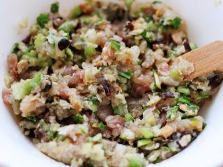 4、超爽的酸汤馄饨,这个时候加入剁碎的白菜和韭菜,木耳,再倒入花生油搅拌均匀即可。