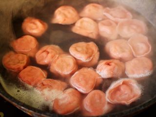 18、超爽的酸汤馄饨,锅中倒入适量的清水煮沸后,把称重的馄饨倒入锅中,大火煮沸后点少许清水,反复3次,看见所有的馄饨都漂浮在水面上即可关火。