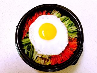 23、韩式石锅拌饭,再加入煎好的溏心蛋，把石锅放在燃气灶上加热，烧制锅内有滋滋的响声即可