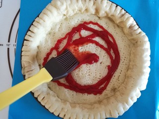 11、圣女果披萨,烤好的披萨胚拿出来，首先刷上番茄酱