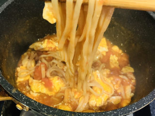 18、鸡蛋西红柿打卤面,把面条先夹起来，起锅了；