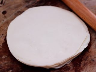 3、三丝春卷～饺子皮版,根据自己的需求，用多少饺子皮，我用了9张饺子皮，把刷油的饺子皮摞在一起，用擀面杖擀成原来的两倍大。