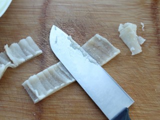 3、洋葱辣椒炒肉皮,用刀刮去猪皮上的油脂