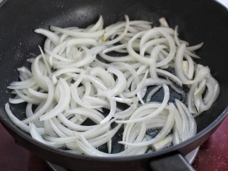 7、洋葱辣椒炒肉皮,锅中放油烧至五成热，倒入洋葱丝炒香