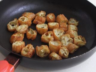 5、油条韭黄炒墨鱼,6.油条剪成小段,干煸至焦脆,盛到碗里 。