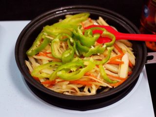 14、家常辣炒土豆丝,大火继续翻炒均匀后，把切丝的青椒放入锅中。