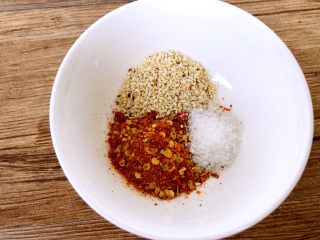 3、麻辣金针菇,辣椒油的做法，取一小碗，加入辣椒粉，白芝麻，盐巴