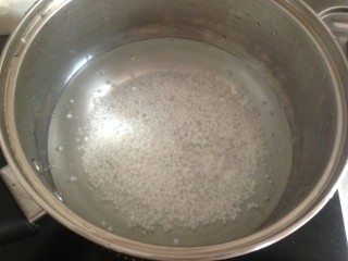 2、牛奶芒果西米露,先煮西米。锅里的水烧开后，放入西米搅拌。水再次煮开后，盖上盖子，焖十分钟。