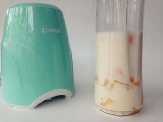 5、牛奶芒果西米露,芒果肉，牛奶，方糖放进便携式果汁机的杯子里。