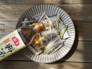 3、红烧带鱼,将葱姜丝一部分铺在带鱼下面，一部分撒在带鱼上面，撒一点盐，加适量料酒，腌制20分钟。