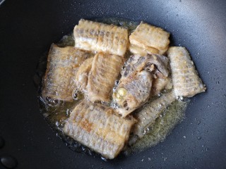 7、红烧带鱼,待到一边煎挺实，颜色微黄了再翻面。